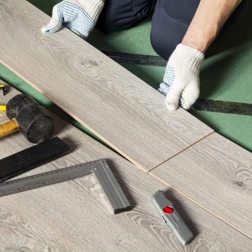 man installs new laminate flooring