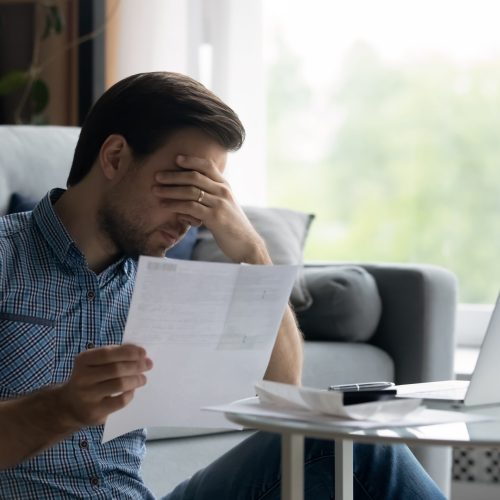 Depressed,Unhappy,Young,Man,Covering,Eyes,Holding,Paper,Document,,Feeling