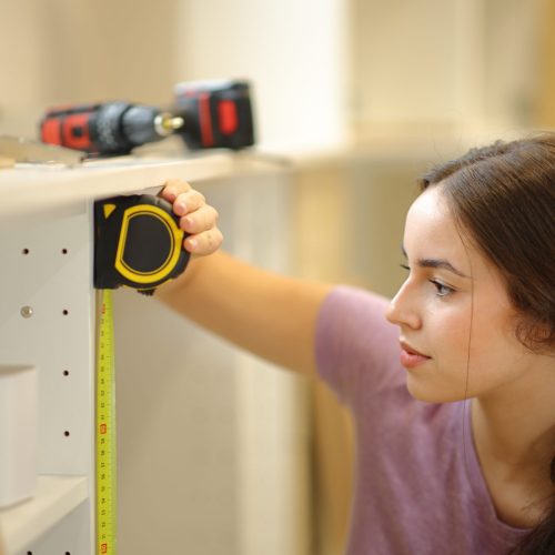 Woman,Taking,Measure,Of,A,Kitchen,Furniture,With,A,Measure
