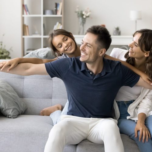 Happy,Hispanic,Parents,And,Little,Kid,Spend,Playful,Time,Seated