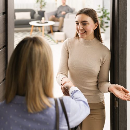 Happy,Woman,Greeting,Neighbor,And,Welcoming,Her,To,Apartment