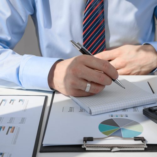 A,Man,Sits,At,A,Desk,And,Fills,Out,Documents,