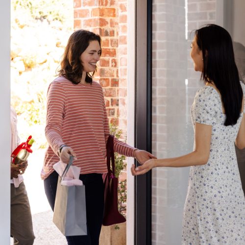 Welcoming,Guests,At,Home,,Women,Exchanging,Gifts,And,Smiles,At